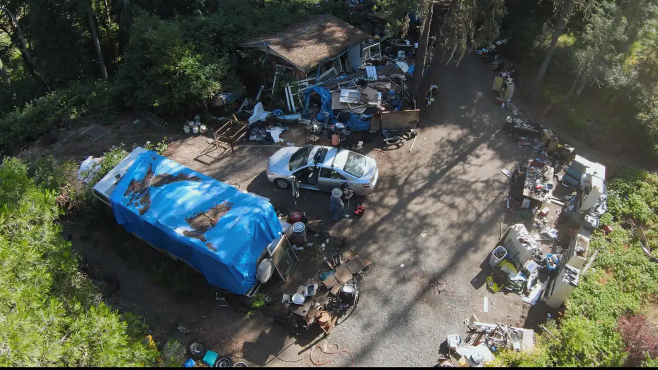 Before: Property with RV and debris needing cleanup